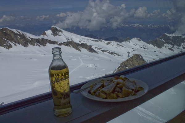 foto af sodavand og pandekageagtig, meget tung og klæg kage i vindue med bjergudsigt