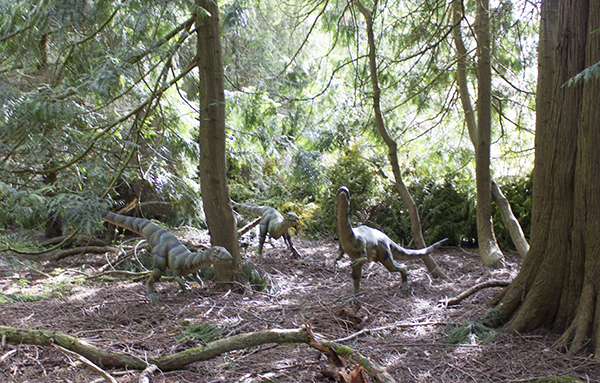 foto af små raptormodeller i skoven